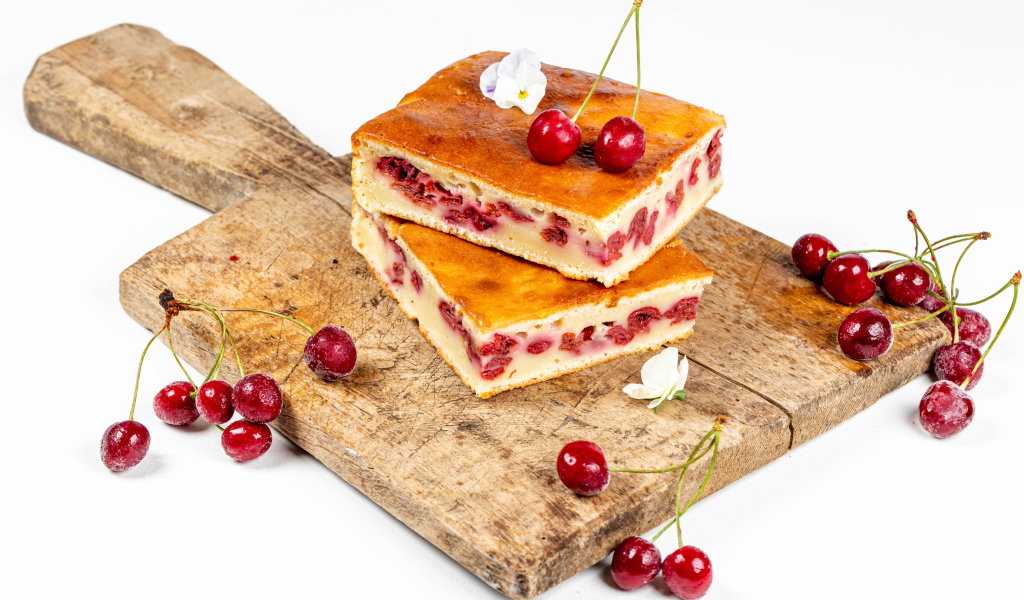 Пирог с вишнями на доске на белом фоне