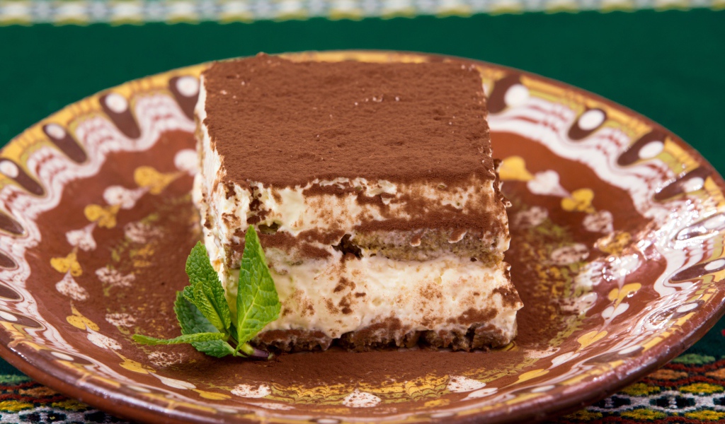 Кусок торта тирамису на тарелке 