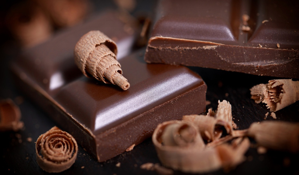 Куски шоколада и стружка на столе крупным планом