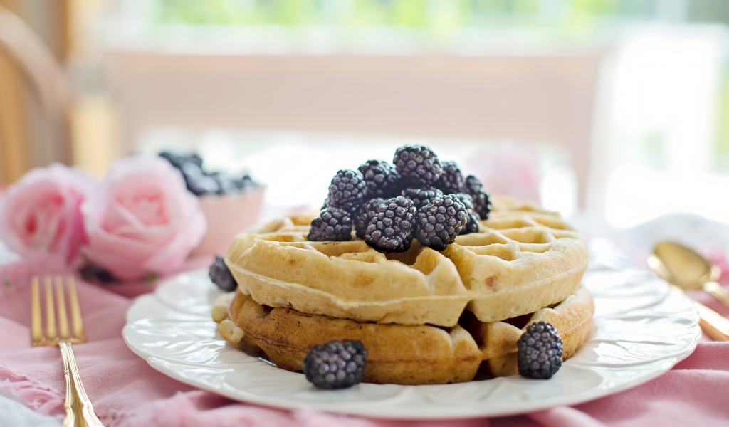 Сладкие вафли на белой тарелке с ягодами ежевики