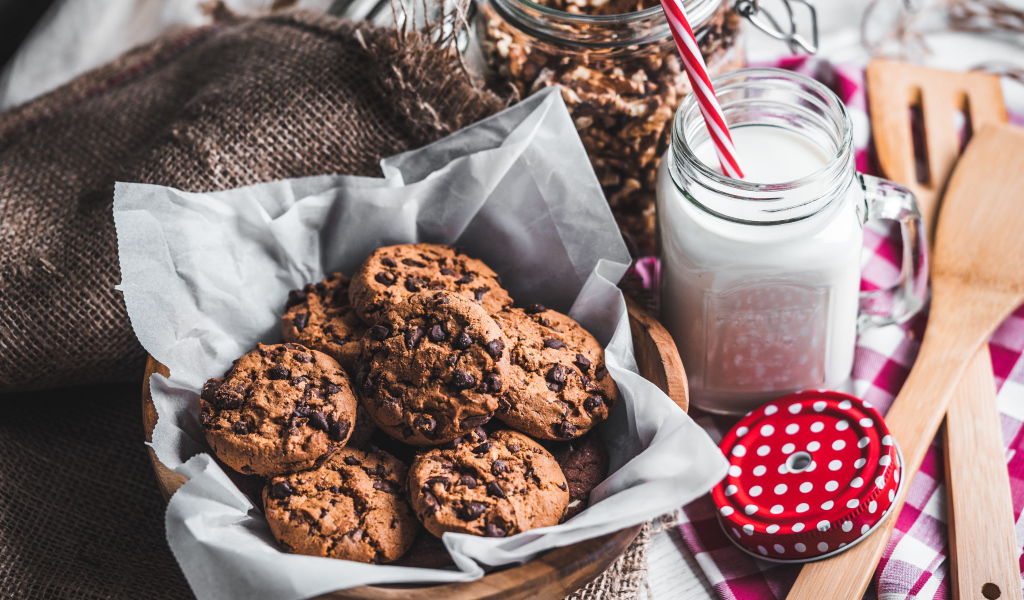 Вкусное печенье с шоколадом на столе с молоком 