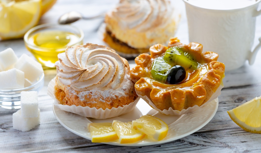Вкусные аппетитные пирожные на тарелке с лимоном
