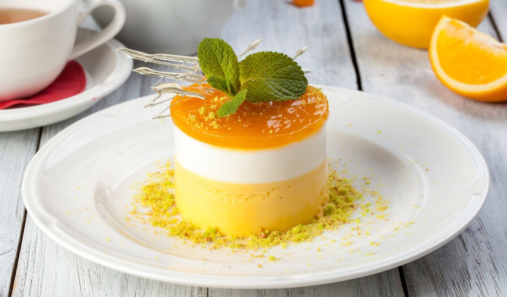 Вкусный десерт с мятой и фисташками на белой тарелке 