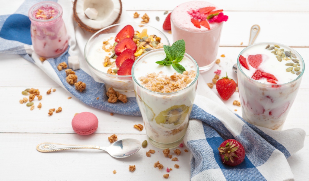 Йогурт с хлопьями и ягодами клубники на столе 