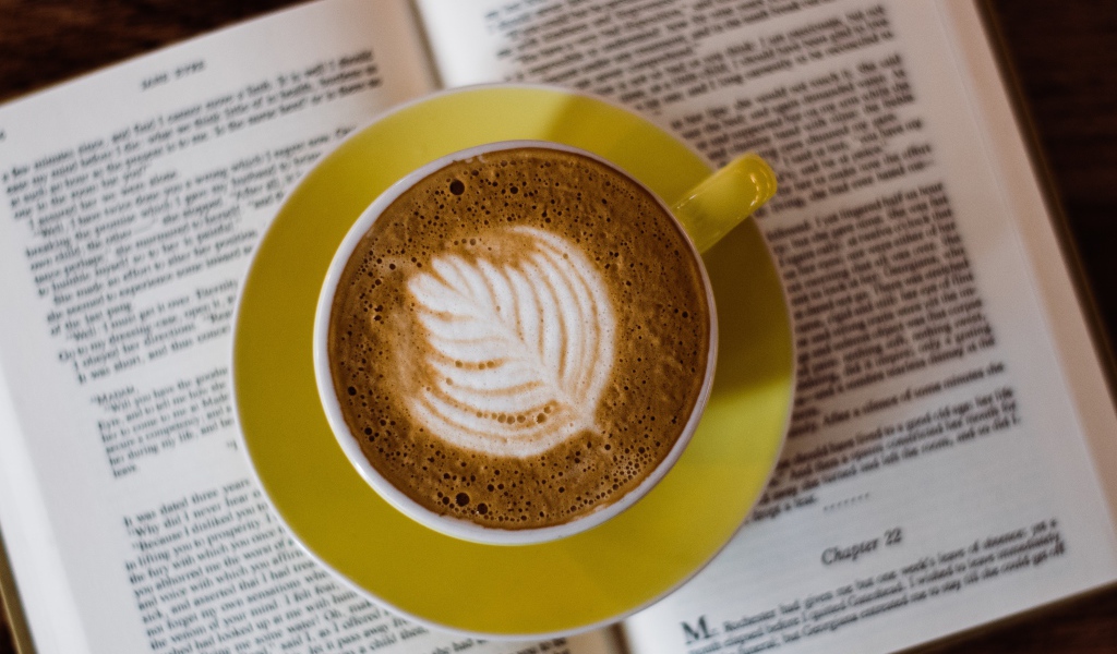 Чашка кофе стоит на книге  