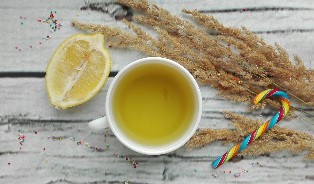 Чашка чая на столе с лимоном и колосьями