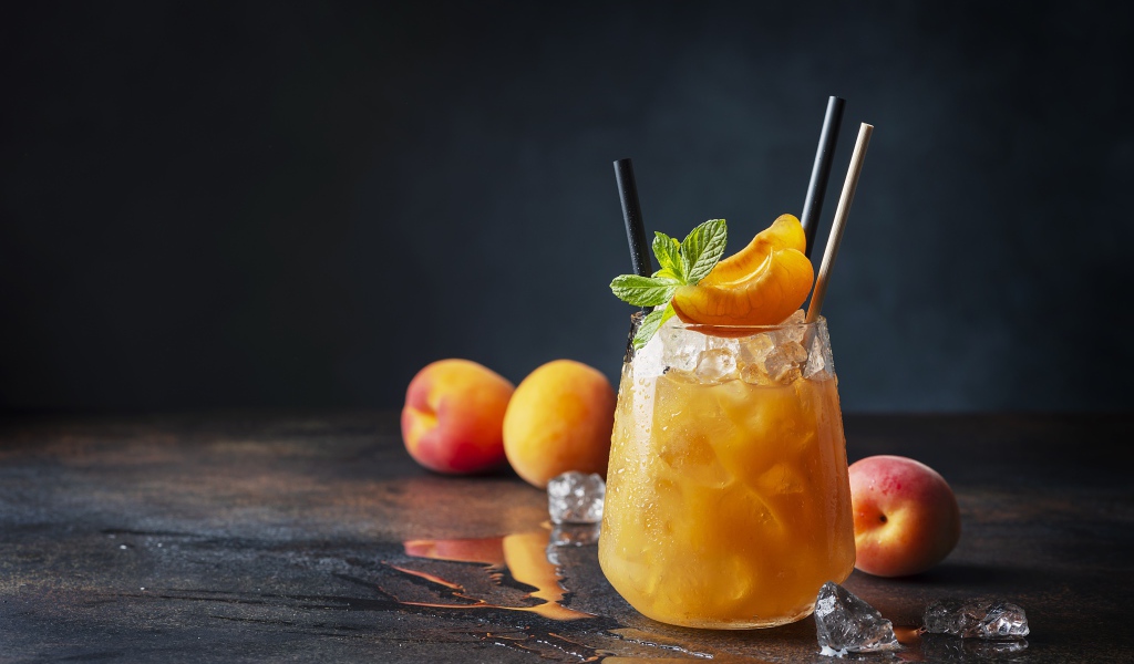 Стакан абрикосового сока со льдом в стакане 