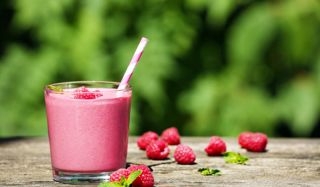 Коктейль в стакане с трубочкой и ягодами малины