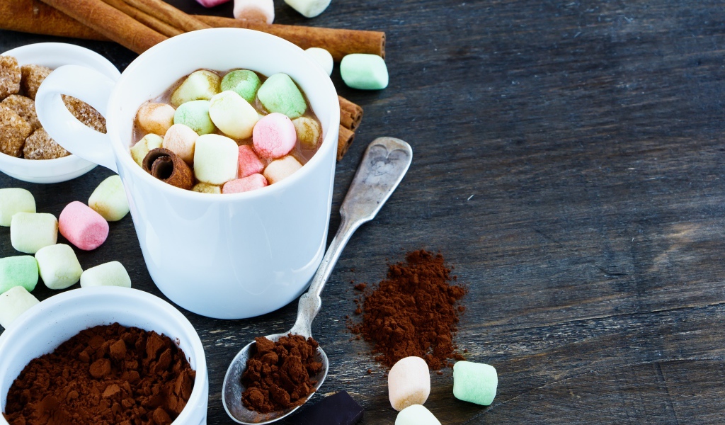 Кофе с маршмеллоу на столе с корицей и сахаром