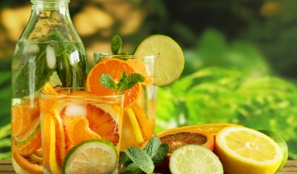 Холодный лимонад на столе с цитрусовыми