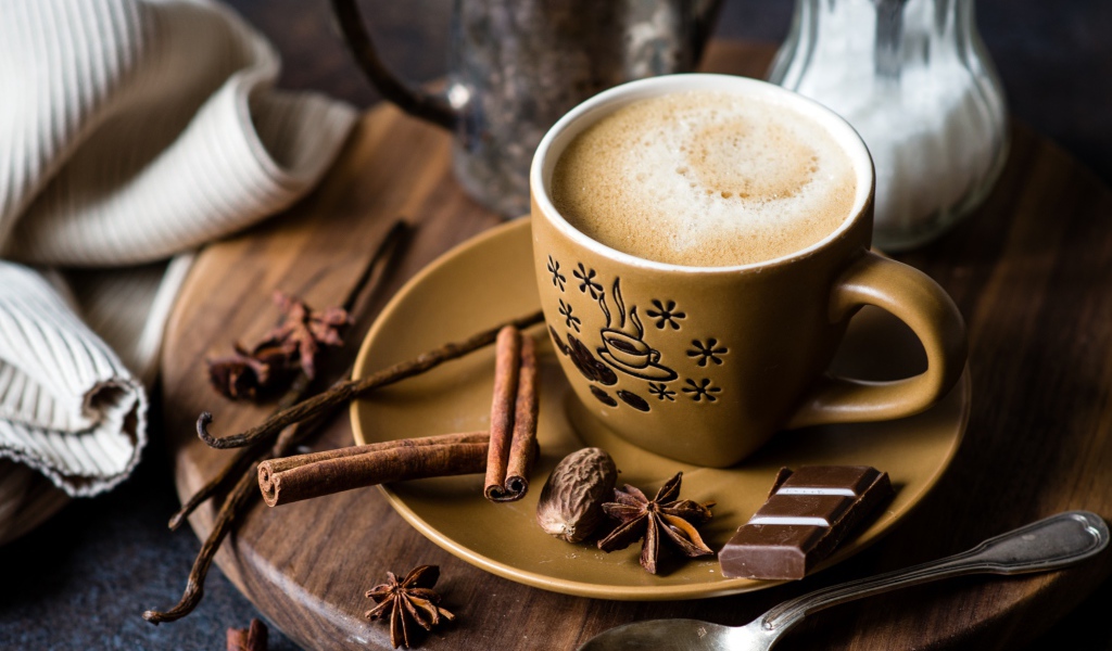 Чашка капучино на блюдце со специями