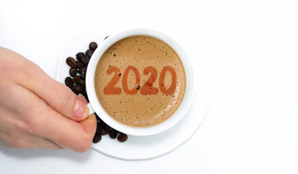 Чашка кофе в руке на белом столе с зернами