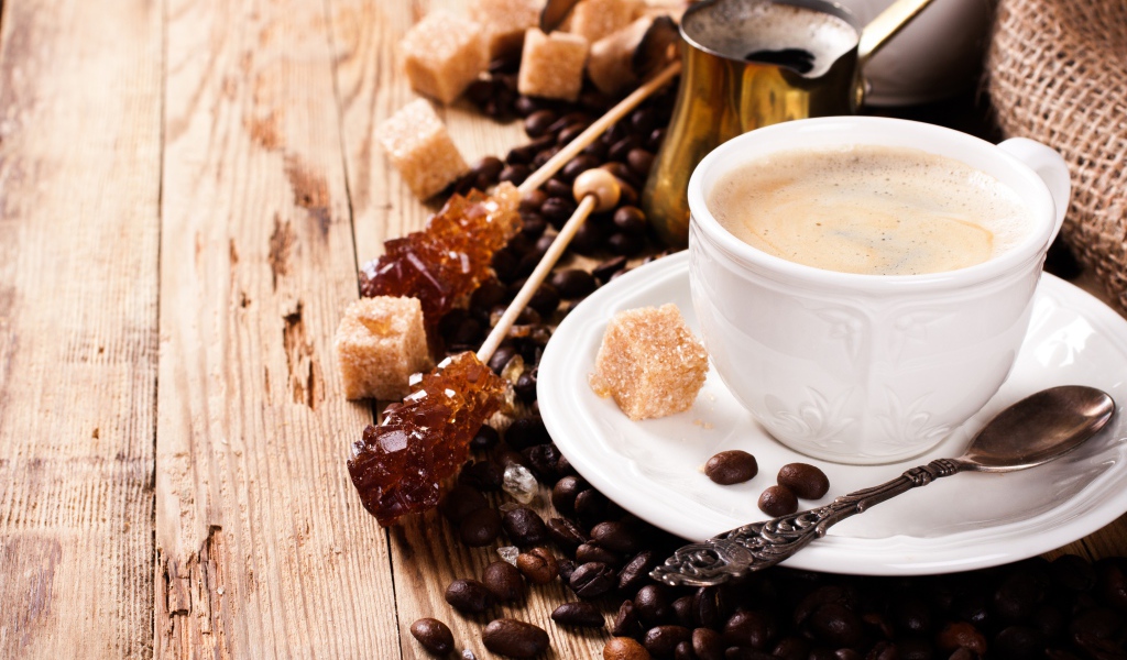 Чашка кофе на столе с леденцами и зернами