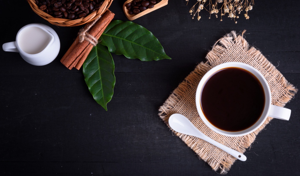 Чашка кофе на столе с корицей и лавровым листом