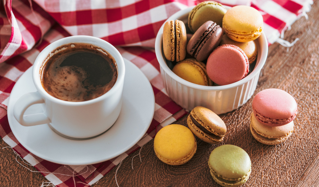 Чашка кофе на столе с десертом макарун 