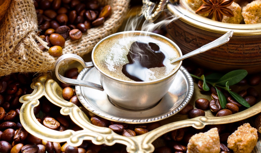 Чашка горячего вкусного кофе на столе с зернами