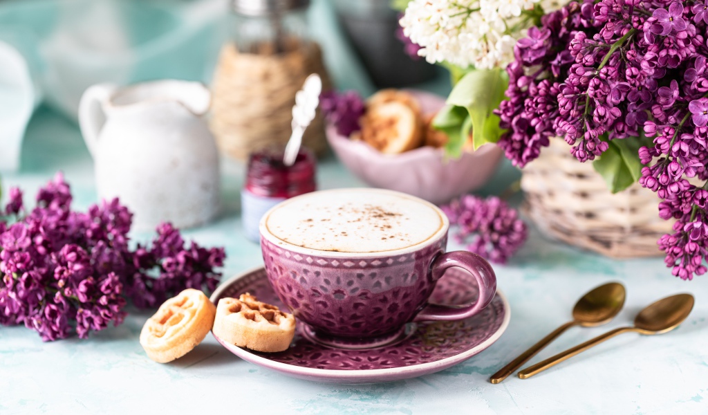 Чашка вкусного кофе с печеньем на столе с букетом сирени