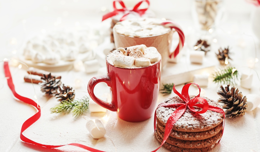 Чашки напитка с маршмеллоу на столе с печеньем