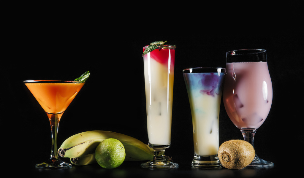 Вкусные тропические коктейли на черном фоне с фруктами