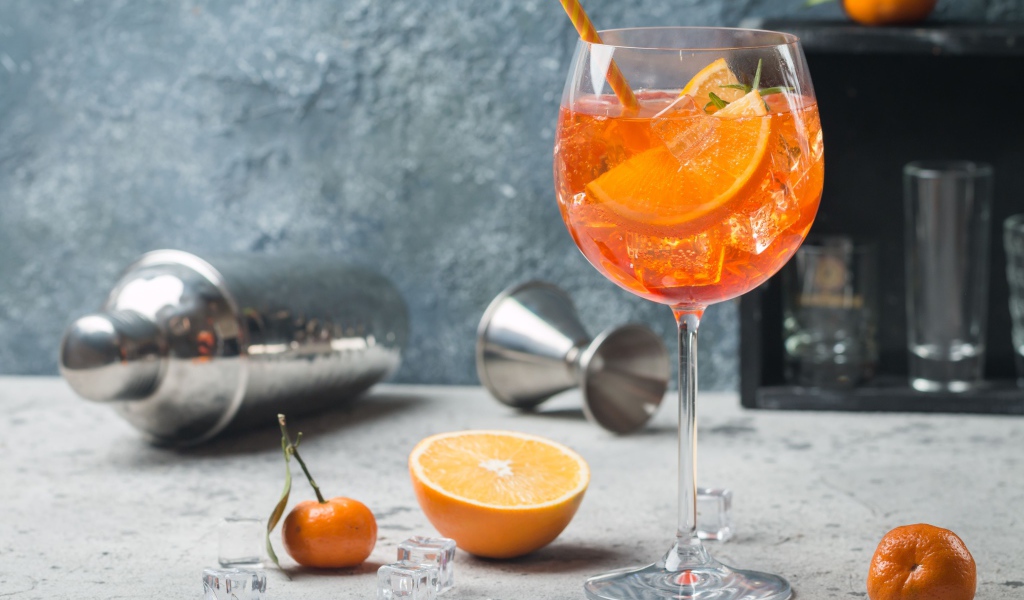 Напиток в бокале со льдом и кусочками апельсина 