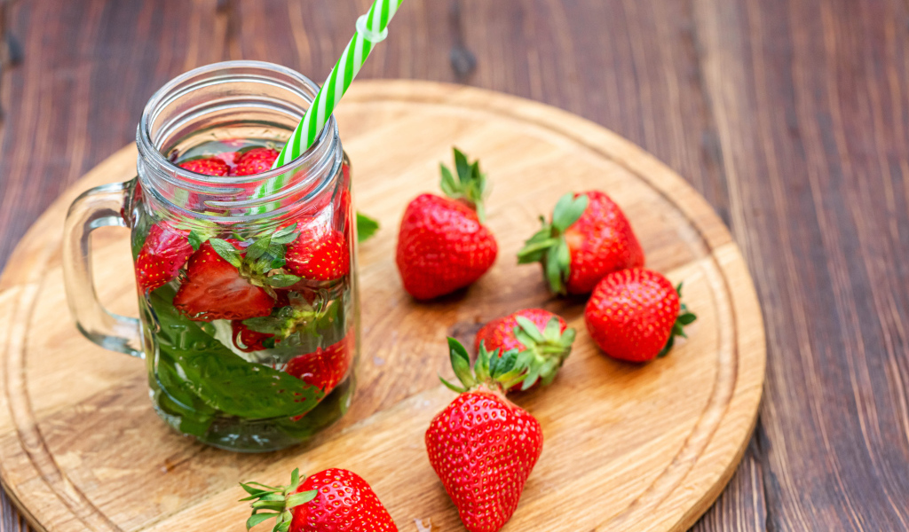 Напиток  в банке с ягодами клубники и трубочкой