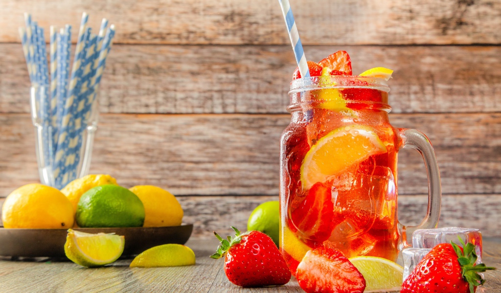 Напиток с клубникой и лимоном в банке на столе 