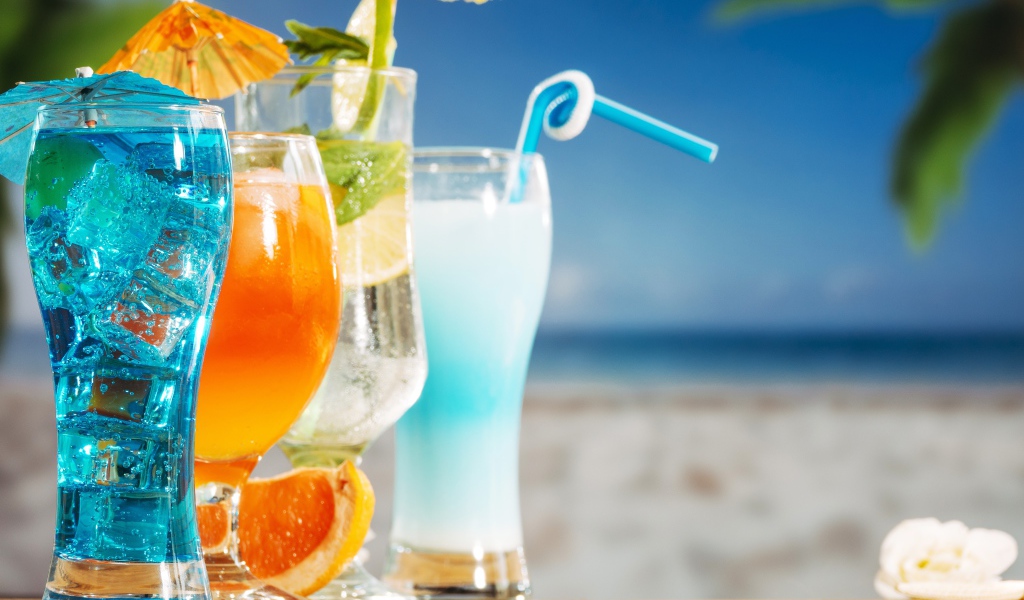 Четыре коктейля стоят на столе пляже 