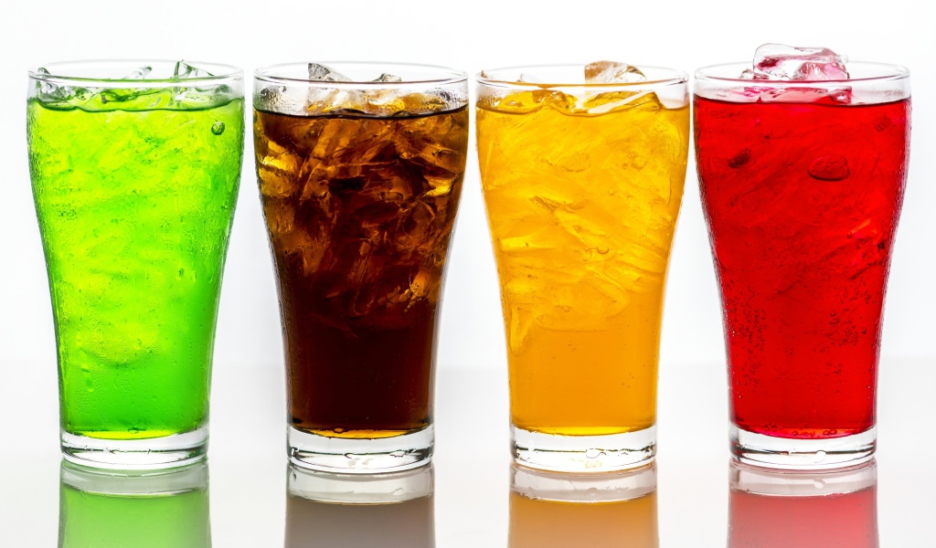 Четыре стакана с напитками на белом фоне