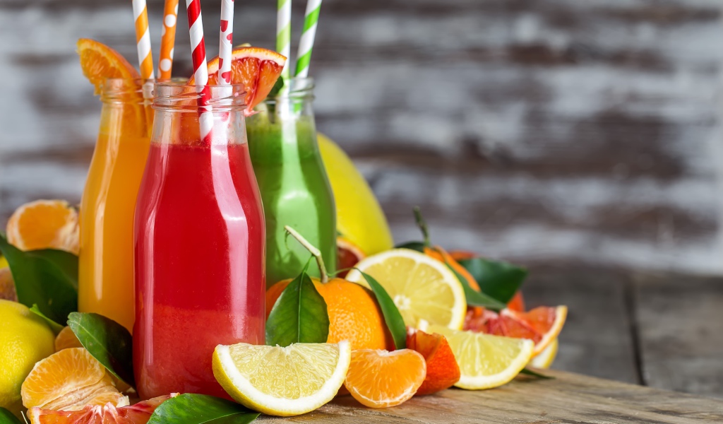 Фруктовое смузи на столе в бутылках с трубочками