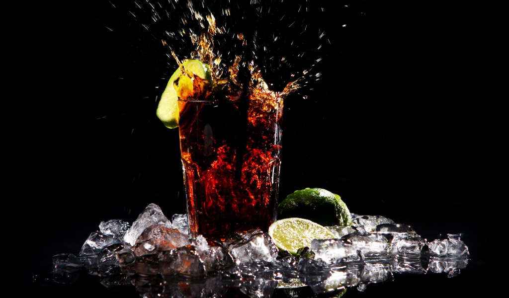 Стакан кока колы на черном фоне со льдом
