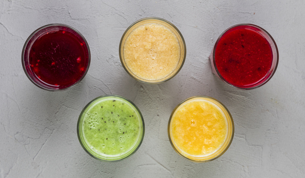 Стаканы с вкусным смузи на сером фоне