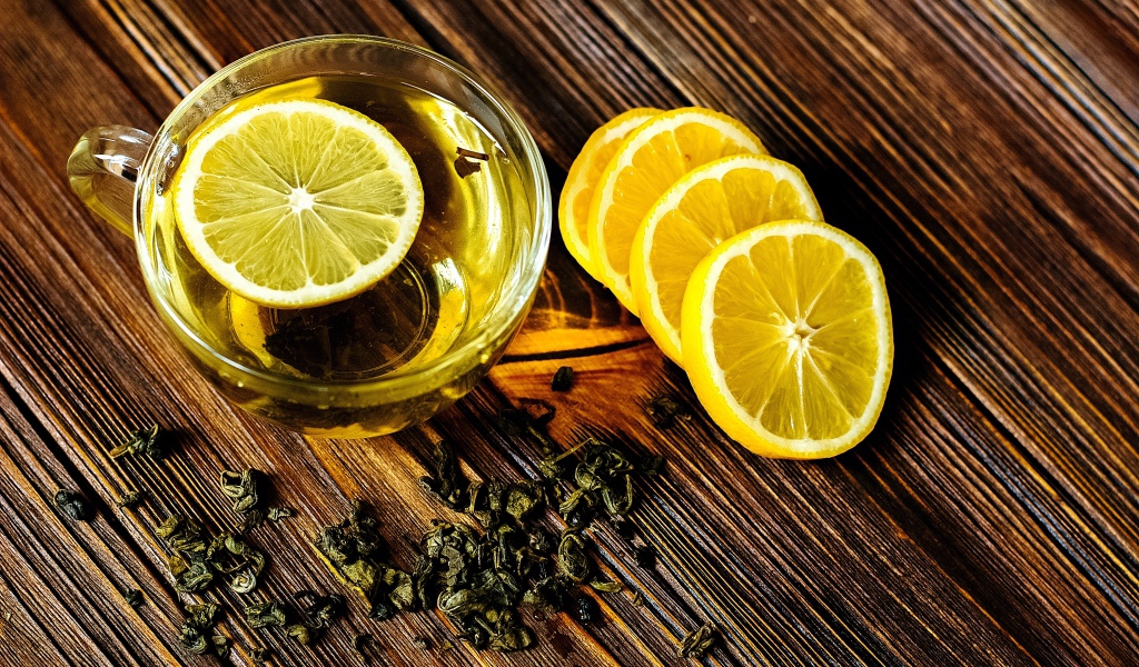 Зеленый чай в стеклянной чашке с лимоном