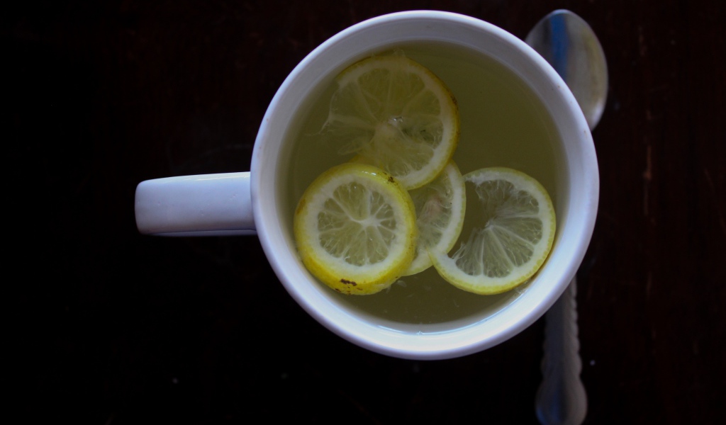 Зеленый чай с лимоном на черном фоне