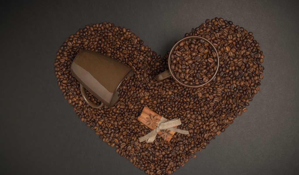 Сердце из кофейных зерен на сером фоне с кружками 