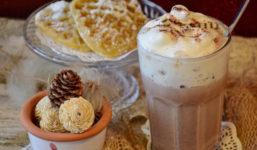 Горячий шоколад со сливками на столе с печеньем