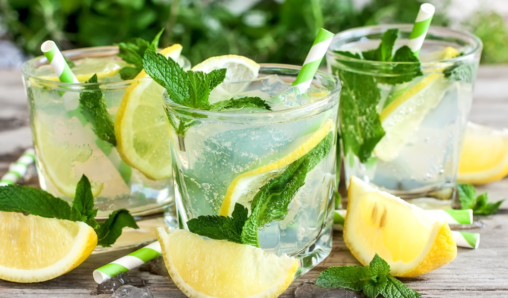 Лимонад с мятой и кусочками лимона в стаканах на столе
