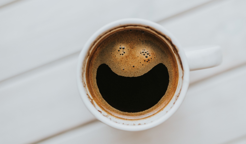 Улыбка на кофейной пенке в белой чашке