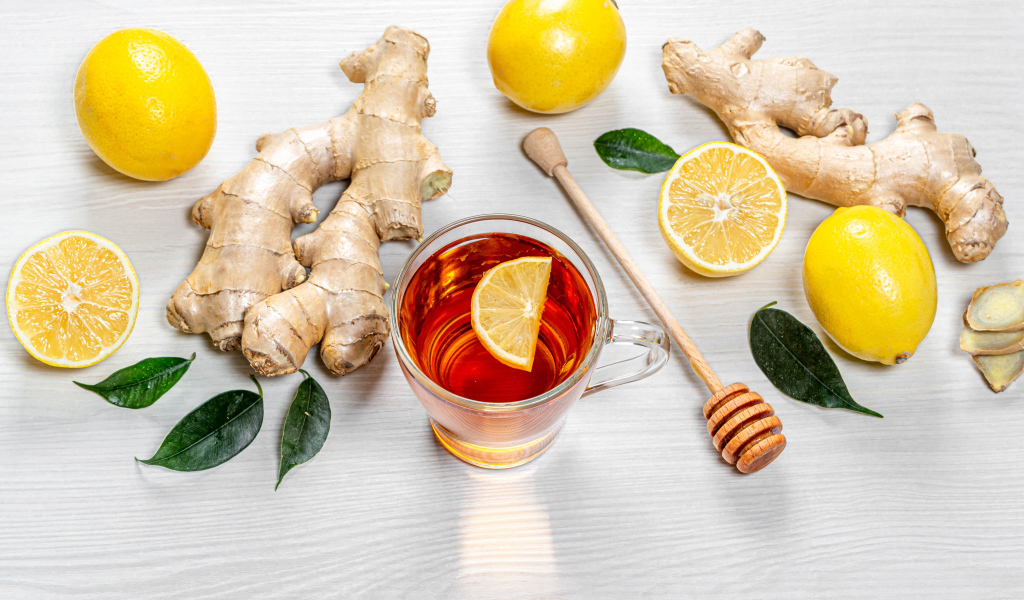 Чай в стеклянной чашке на столе с лимоном и имбирем 