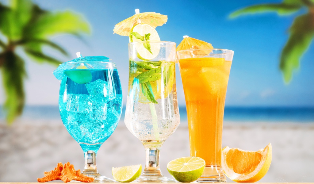 Три вкусных тропических коктейля стоят на пляже
