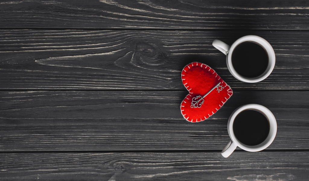 Две чашки кофе на столе с сердцем и ключом