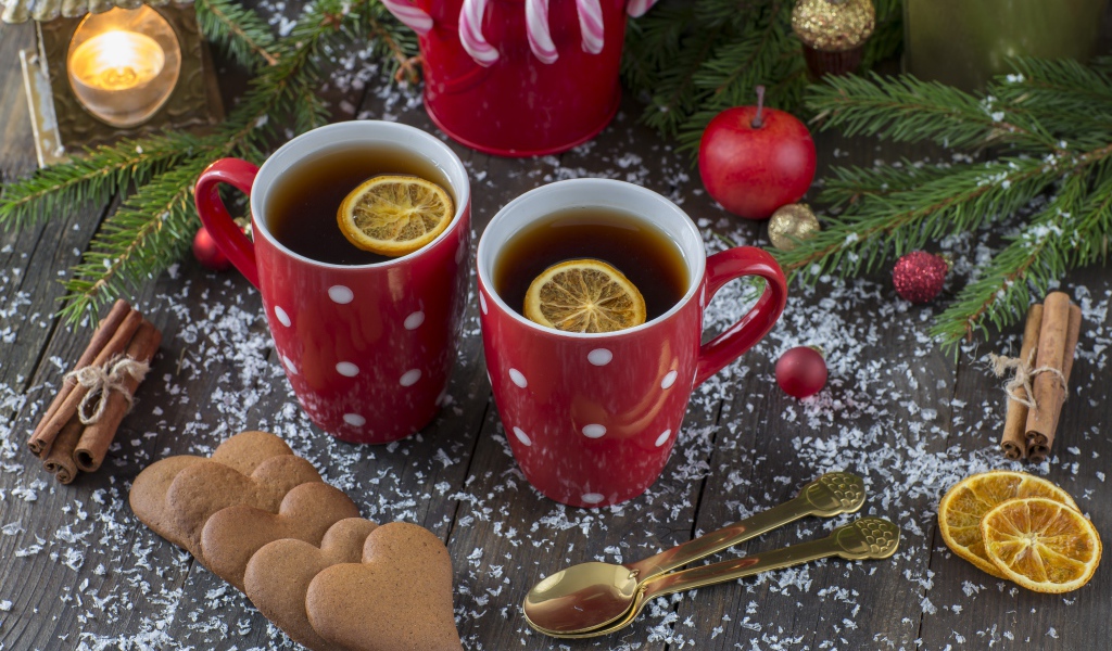 Две чашки чая с лимоном на столе с печеньем и еловыми ветками