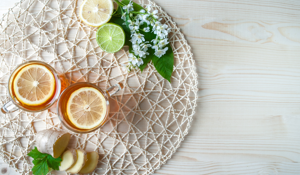 Две чашки чая с лимоном на плетеной подставке 