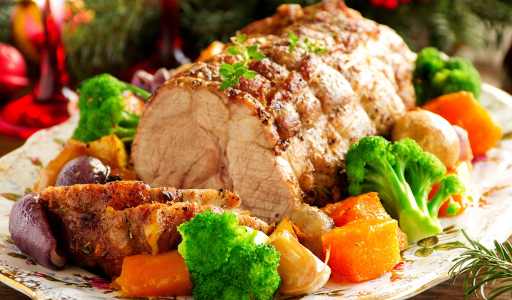 Кусок запеченного мяса на тарелке с овощами