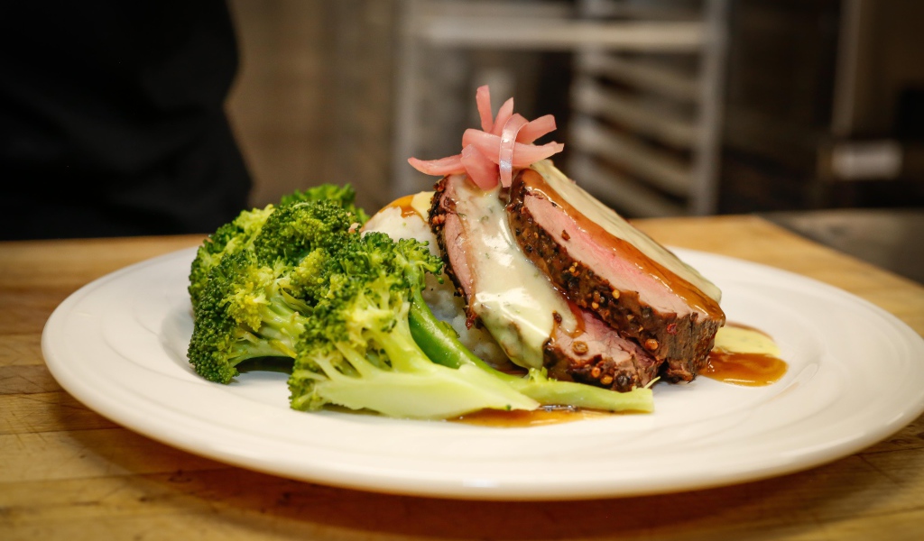 Брокколи на тарелке с кусочками запеченного мяса 