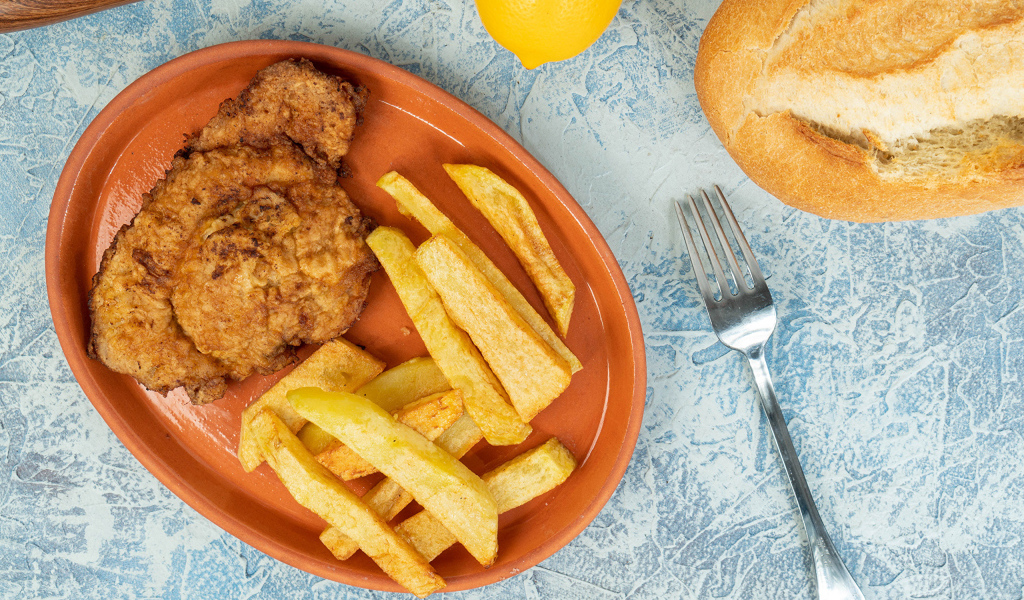 Отбивная с картофелем фри на тарелке 