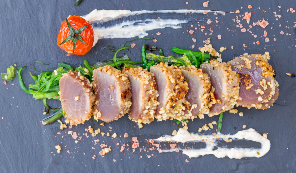 Вяленое мясо на столе с зеленью и помидором 