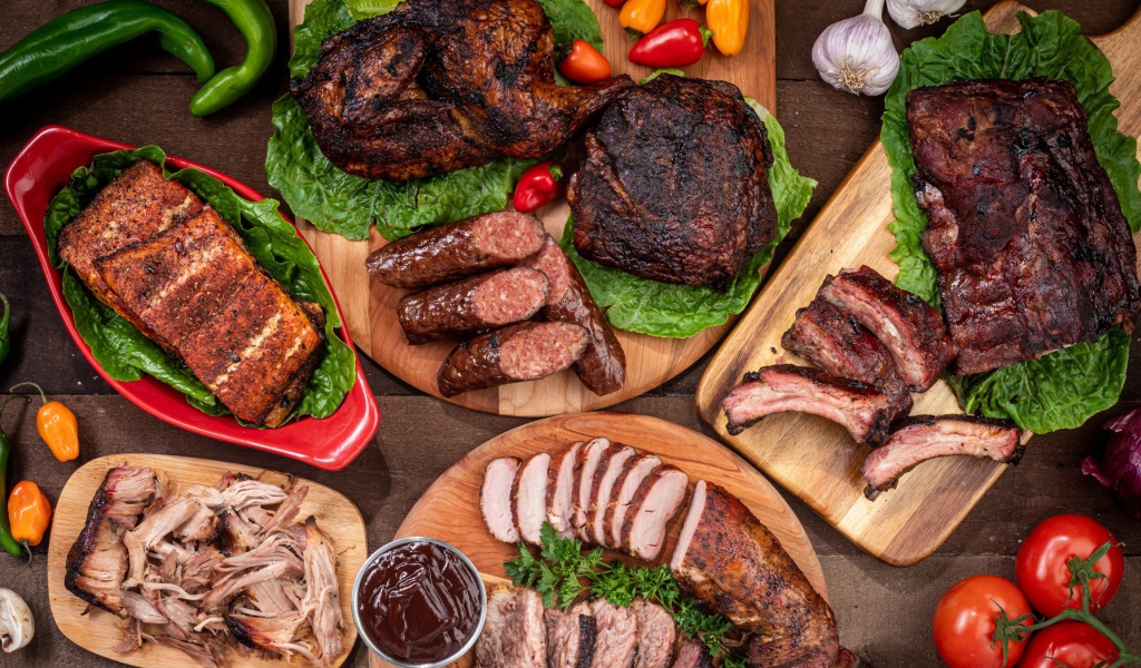 Вкусные запеченные мясные продукты на столе с овощами 