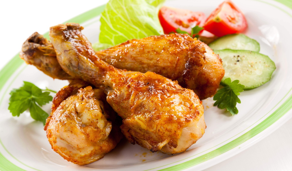 Зажареные куриные ножки на тарелке с овощами
