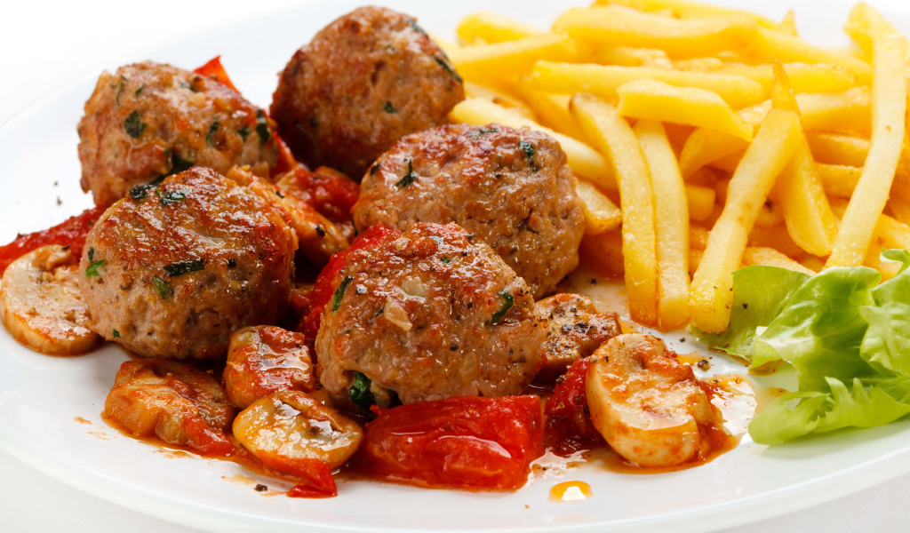 Тефтели с картофелем фри и овощами на белом фоне