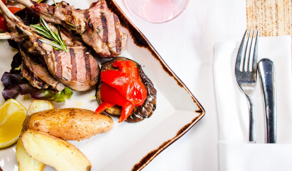 Свиные ребрышки с овощами на столе 